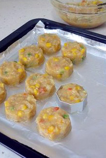 5、创意西餐：让小朋友喜爱的烤鳕鱼饼 ,烤盘中锡纸上刷一层薄油（防粘）在模具中塞满鱼饼料，然后用勺子按压住饼料，再将模具轻轻提起即可。