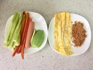 1、牛油果肉松寿司,将胡萝卜和黄瓜洗净，去皮，切成条，胡萝卜放沸水里焯熟；牛油果去皮切片；鸡蛋打散煎熟，再切成条；肉松准备好。