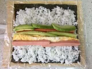 4、牛油果肉松寿司,把各种食材放到米饭中间。