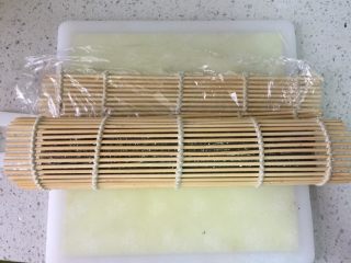 7、牛油果肉松寿司,然后借助寿司席把各种食材卷在米饭和海苔里，注意压紧。