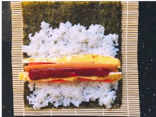 4、寿司,铺上米饭，放上切好的食材。卷起来。