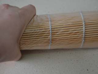 17、寿司,将寿司帘卷起，最后用双手轻轻握下定型。