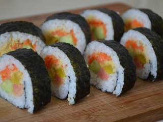 21、寿司,准备一个湿布，刀每切一下最好擦干净再切，不然会粘米粒，第二刀会很粘。依次切好。