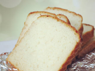 5、云朵一样绵软的北海道吐司面包,再次每个面团压平,宽度不变,长度能卷3圈即可,并列放入吐司模最后发酵(注意留出发酵膨胀的空间),发到土司盒8-9分满就好