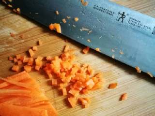 2、黄金如意卷#挑战鸡蛋的100种做法#,用一小段胡萝卜切片后改刀成细小的粒。