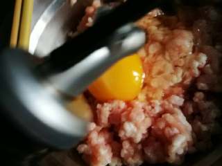 4、黄金如意卷#挑战鸡蛋的100种做法#,肉糜里打入一个鸡蛋，加适量料酒，生抽。