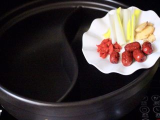 12、海鲜麻辣鸳鸯火锅,在鸳鸯火锅的一边加入葱段、姜片、枸杞和红枣