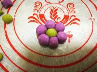 7、花朵汤圆,把绿色小球放中间，周围放上6个紫色圆球蘸水粘到一起。