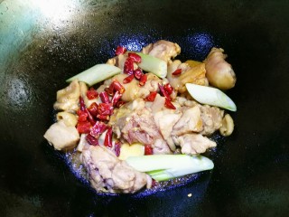 6、红烧鸡块,干辣椒，葱段一块儿放入继续翻炒。