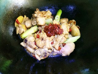 8、红烧鸡块,一汤匙豆瓣酱放入后，沿锅边烹入料酒。