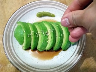 6、牛油果刺身,最后在牛油果片上撒上白芝麻，就可以食用了。