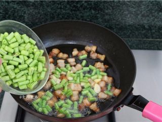 8、五花肉蒜香腊味焖饭,加入豆角炒至皮起皱