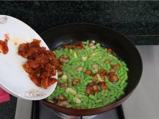 9、五花肉蒜香腊味焖饭,接着倒入腊肠、翻炒均匀