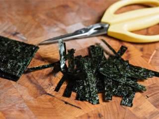 5、蔬菜盖饭配山葵蛋黄酱,寿司海苔 叠起来，纵向切成三等分，叠起来，然后用厨房剪刀剪成0.5厘米宽的条状。