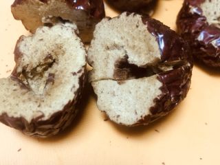 3、老北京清真小吃-糖卷果,这里说一下去枣核的小窍门:将刀垂直于枣核的方向把枣一分为二的划一圈,然后用手掰开,这时候已经有一半的枣肉与枣核分开了,然后轻轻掰开另一半,枣核很容易包出来了。