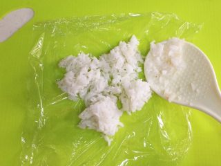 9、鲜虾时蔬饭团便当,在150克的米饭中加入少许寿司醋拌匀，然后取一份50克米饭放在保鲜膜上。