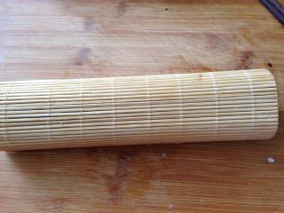 8、清甜玉米寿司,借助寿司帘把米饭卷起来,卷紧