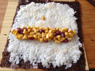 9、清甜玉米寿司,还有一种方法,在米饭的一端放入玉米粒,然后卷起来