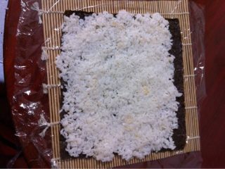 5、日本菜 寿司,把拌好的米饭铺在海苔上压实，前面留1厘米左右不铺米饭，沾点水抹上(照片颠倒了)