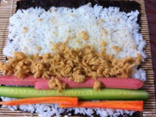 6、日本菜 寿司,铺上切成条的黄瓜、胡萝卜、火腿肠，再铺上肉松