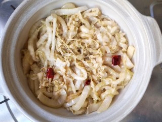 13、酸菜排骨暖锅,取砂锅,底部放入炒好的酸菜丝。