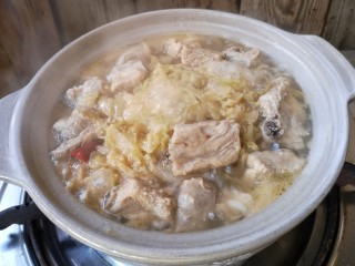15、酸菜排骨暖锅,倒入排骨汤,开小火咕嘟咕嘟……记得多煮一阵子,让肉香融入酸菜中。