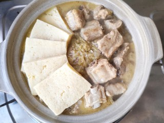 16、酸菜排骨暖锅,将冻豆腐煮到酸菜排骨锅里,冻豆腐渐渐鼓胀,蜂窝状的纹理中,吸饱了酸香馥郁的汤汁,是整锅的精髓。