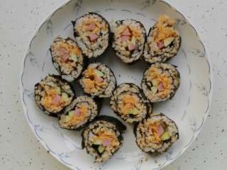 5、寿司,将寿司刀蘸点水，把寿司切成一段，放在盘里摆好。