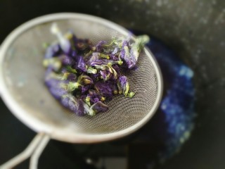 4、#辅食计划#“蓝钻”水果寿司,然后大米淘洗好，将蝶豆花好倒入大米里浸泡半个小时