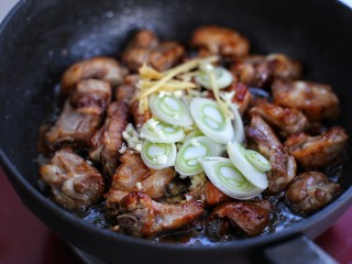 8、排骨焖饭,接着放入葱花、蒜末和姜丝翻炒均匀