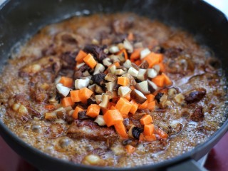 10、排骨焖饭,倒入热水和排骨持平，改中小火炖煮约半个小时，待锅内剩少许汤汁时加入香菇和胡萝卜翻炒均匀