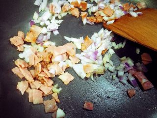 4、乌饭寿司卷,利用蒸糯米饭的时间，我们把培根，香肠，洋葱放在锅里稍微炒一下。