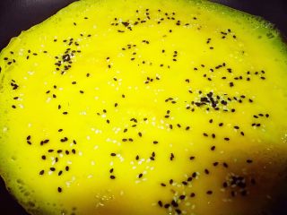 8、乌饭寿司卷,趁着鸡蛋液还没完全凝固的时候，撒黑白芝麻。