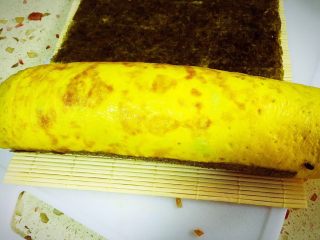 12、乌饭寿司卷,寿司铺好，把刚才卷好的鸡蛋饭放在上面。