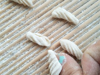 5、炒三色贝壳面,把切成丁的面块在拍子上用大拇指搓成贝壳????形状（也可放在寿司帘上去搓）