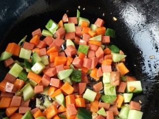 8、炒三色贝壳面,锅中放油放入配菜丁翻炒，然后放入贝壳面，少于生抽，老抽，上颜色