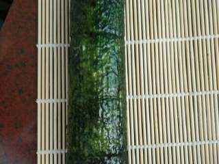 4、普通寿司,用竹板卷好饭团。