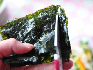 4、#明天吃什么？#吞拿鱼饭团便当,将紫菜切成合适的条状大小，剩下的就捏成碎碎加进饭里 