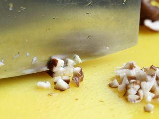 7、香菇肉酱饭,将香菇去蒂洗净,切碎粒。切好后用手将香菇多余的水分挤去。