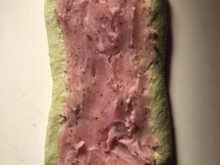 1、樱花抹茶豆沙面包,静置后，擀成舌型，抹上樱花豆沙