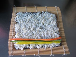 1、寿司面包卷：来个口味丰富的咸面包换换口味,先制作寿司。剩米饭用微波炉加热至温热，倒入寿司醋搅拌均匀。寿司海苔铺在寿司帘上，再均匀的铺上米饭，起始端放入黄瓜条、胡萝卜条、寿司萝卜条。