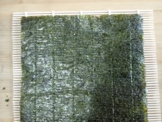 4、快手寿司,把寿司紫菜放到帘子上，注意！敲黑板！糙面朝上。