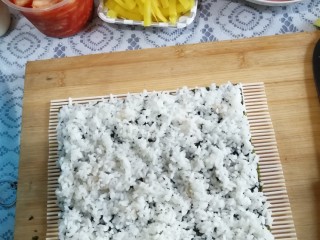 5、快手寿司,铺上米饭，注意！注意！成功与否就在这步了！边上比中间更重要，不要忽视边缘，认真铺均匀。
