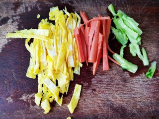 2、肉松寿司,把鸡蛋用筷子或者打蛋器打散，平底锅倒入少许油，将鸡蛋煎成鸡蛋饼，火腿肠用水煮一下或者煎一下都可以（个人不喜欢吃生的火腿肠），黄瓜去皮，然后把食材都切成条状备用