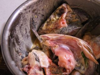 4、砂锅鱼头,④腌制好的鱼头去掉姜葱,沥干水分,加入鸡蛋黄混匀,再倒入生粉拌均匀,准备下锅煎。
