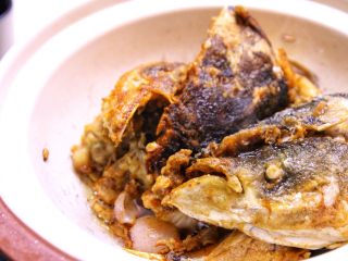 7、砂锅鱼头,配料的香味出来后,将鱼头摆入,盖上盖子微微焖焗1分钟。