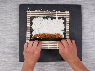 3、金枪鱼军舰寿司与咸蛋黄肉松寿司卷,等待饭冷却的时间，可处理其它食材，将咸蛋 抠出咸蛋黄放入碗中压碎后倒入肉松搅拌均匀；开大火将锅烧至冒烟，倒入10毫升橄榄油以及咸蛋黄肉松翻炒大约30秒后盛出备用。将小黄瓜 洗净切成8条，去籽备用。