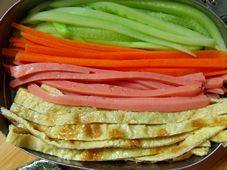 4、太阳花寿司,鸡蛋摊皮切丝，黄瓜胡萝卜火腿切丝焯水烫一下。