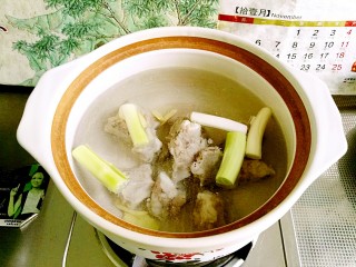 3、美容豆浆火锅,焯过水的排骨捞出，温水洗去血沫，放进砂锅，放入葱段和姜片，倒入2勺料酒