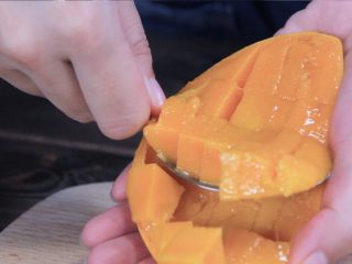 11、泰式芒果椰汁西米糕,用勺子挖出果肉。